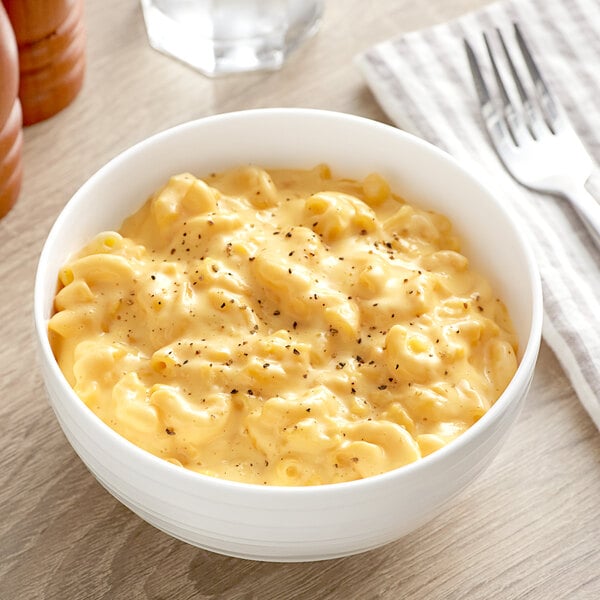 A bowl of macaroni and cheese with a fork.