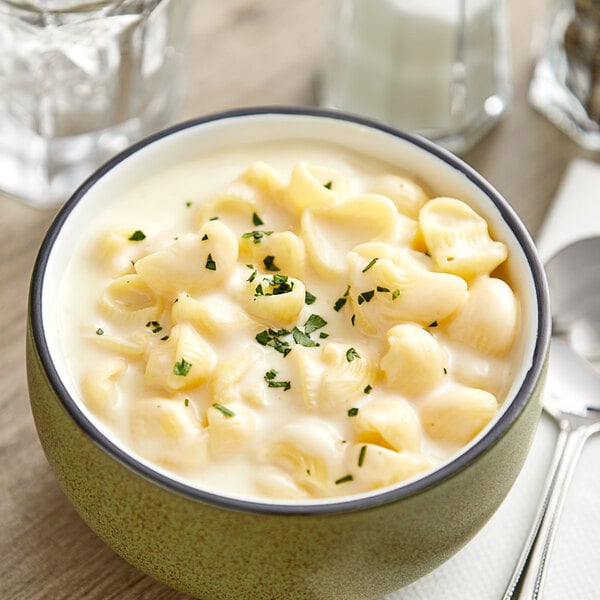 A bowl of Kettle Collection Vermont White Cheddar Macaroni and Cheese with a spoon.