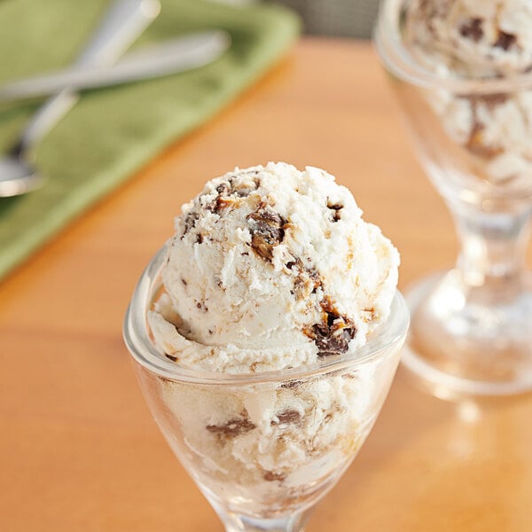 A glass of ice cream topped with a scoop of Gertrude Hawk Mini Milk Chocolate Sea Salt Caramel Truffle.