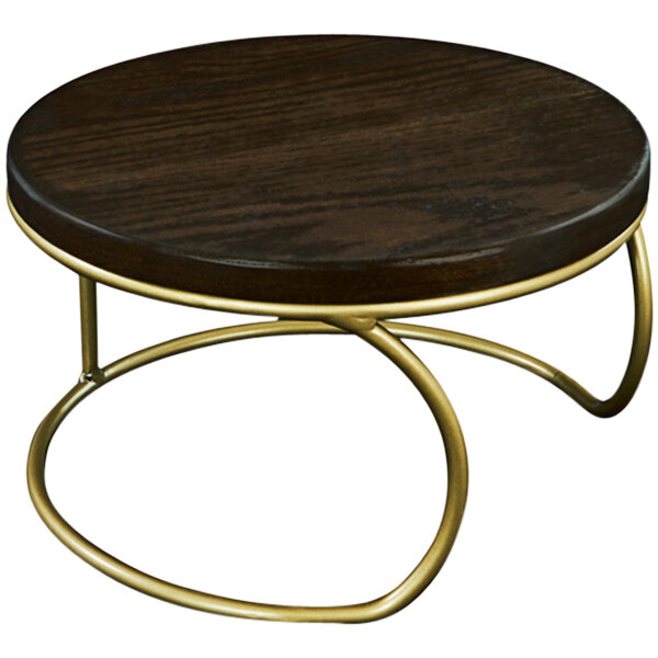 A round wooden display riser with gold metal legs.