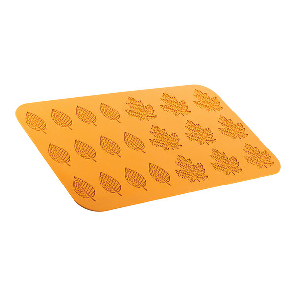 A yellow silicone mat with leaves carved on it.