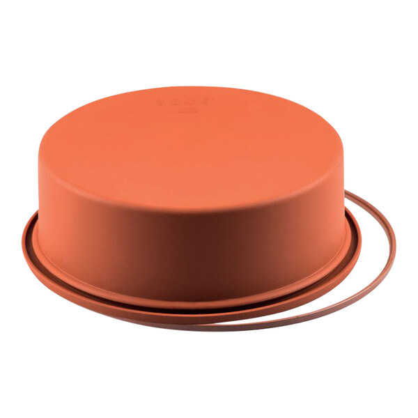 A round orange Silikomart silicone baking mold with a rubber ring around the top.