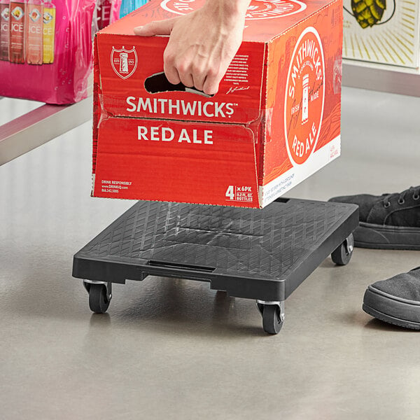 A hand holding a red box over a black Regency solid-surface dolly platform with wheels.