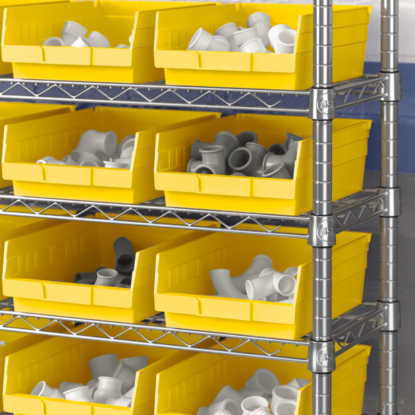 A shelf with yellow Regency shelf bins holding white objects.
