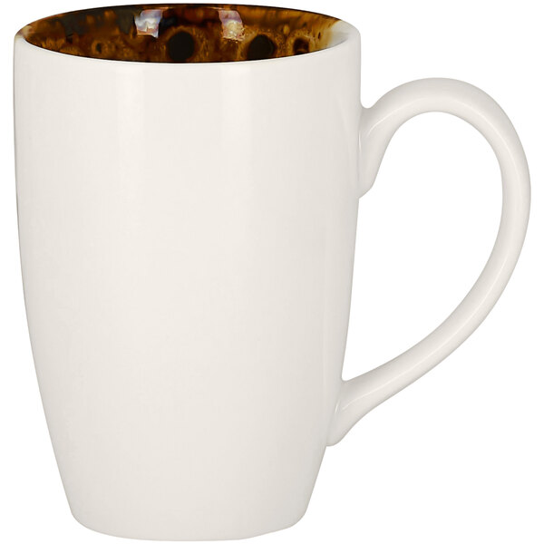 A white porcelain mug with brown spots and a brown rim.