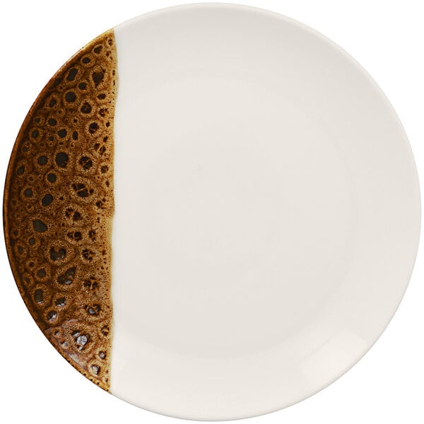 A white porcelain coupe plate with brown and white designs.