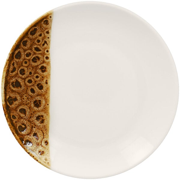 A white RAK Porcelain coupe plate with brown spots.
