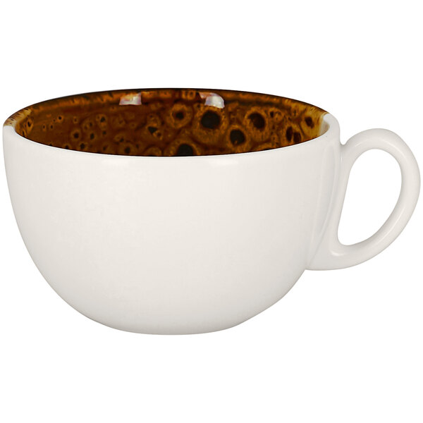A white porcelain breakfast cup with brown spots on it.