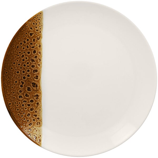 A white porcelain plate with brown speckles on it.