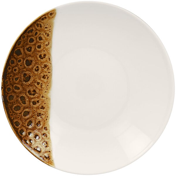 A white porcelain plate with brown speckles and a brown edge.