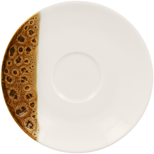 A white saucer with brown spots on it.