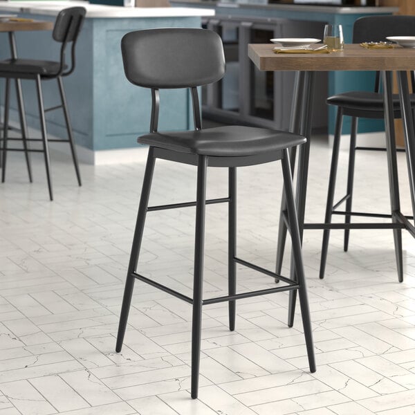 A Lancaster Table & Seating black barstool with black vinyl seat and backrest.