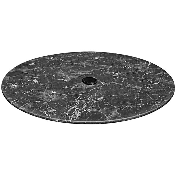 A round black marble table top with a hole in it.