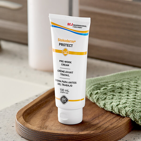 A white tube of SC Johnson Professional Stokoderm Protect hand cream with blue and orange text.