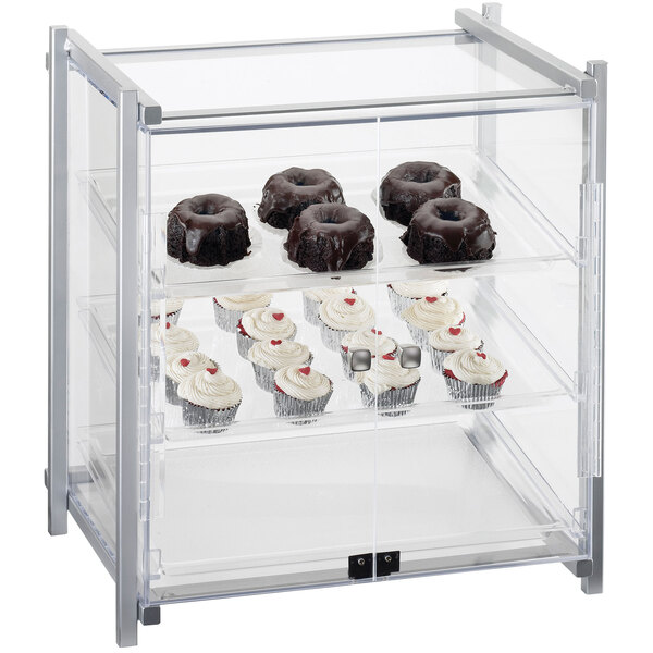 A Cal-Mil silver display case with cupcakes, muffins, and chocolate donuts.