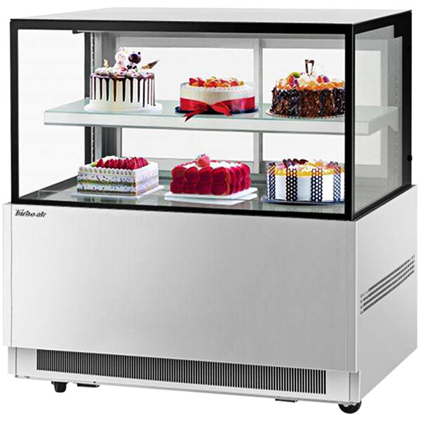 A Turbo Air refrigerated bakery display case with cakes on two tiers.