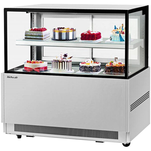 A Turbo Air refrigerated bakery display case with cakes and desserts on two tiers.