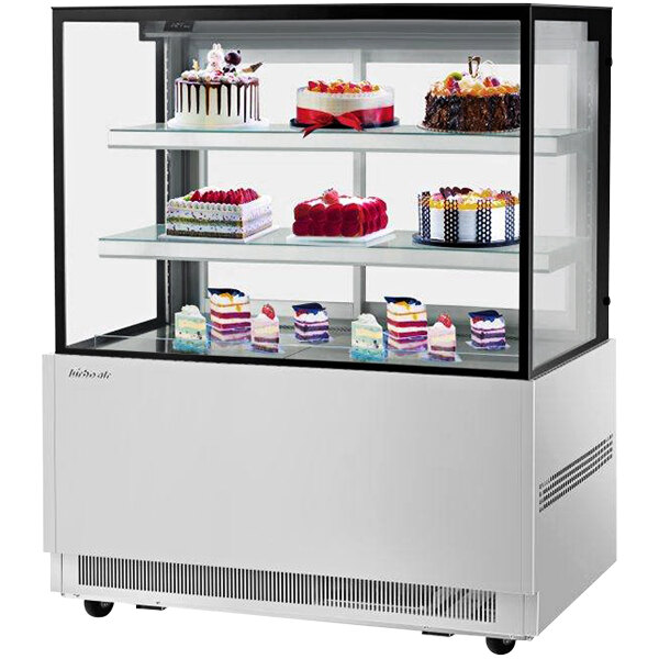 A Turbo Air refrigerated bakery display case with cakes on it.