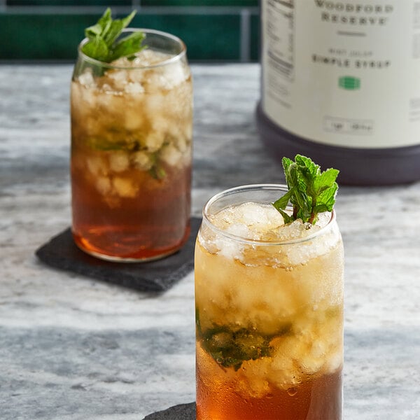 Two glasses of iced tea with mint leaves.