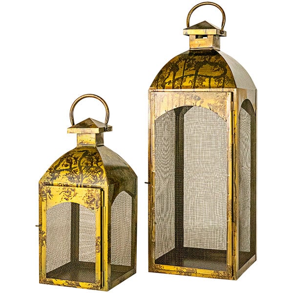 A pair of gold metal lanterns with wire mesh covers.