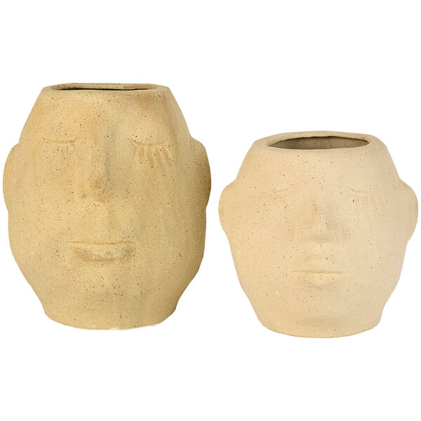 Two white ceramic pots with faces on them.