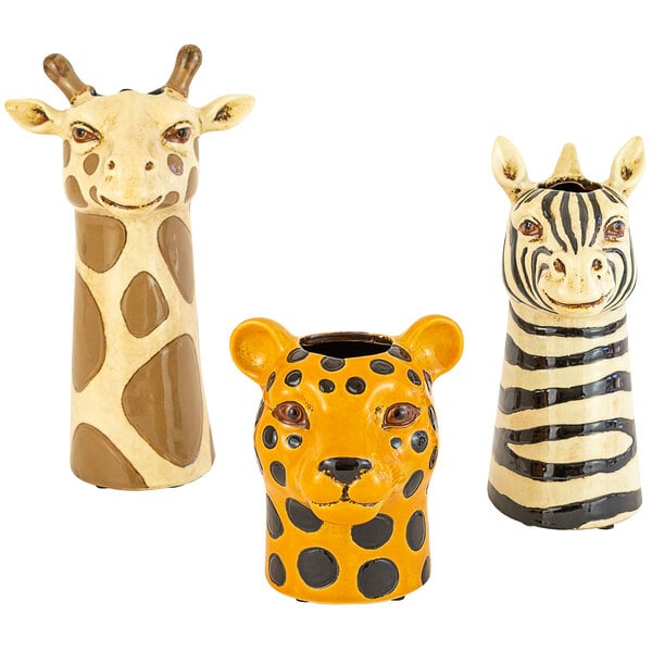 A group of ceramic safari animal succulent holders including a yellow and black spotted giraffe, a zebra, and a giraffe with black stripes.