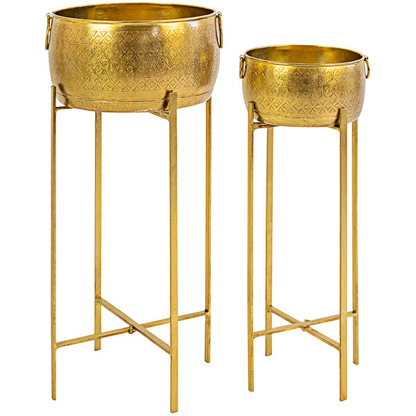 A pair of gold metal planters on stands.