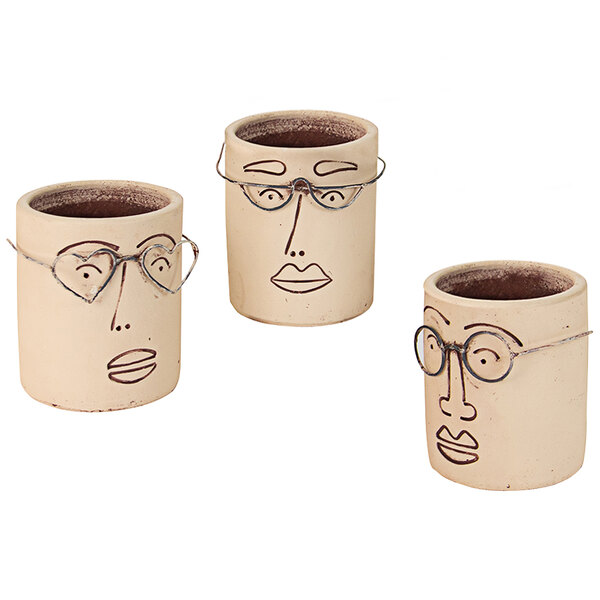 A set of three clay pots with faces drawn on them.