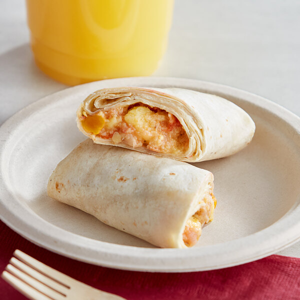 An El Monterey breakfast burrito on a plate with orange juice.