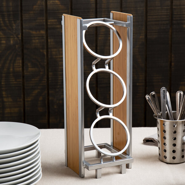 A Cal-Mil bamboo flatware holder with three vertical metal cylinders.