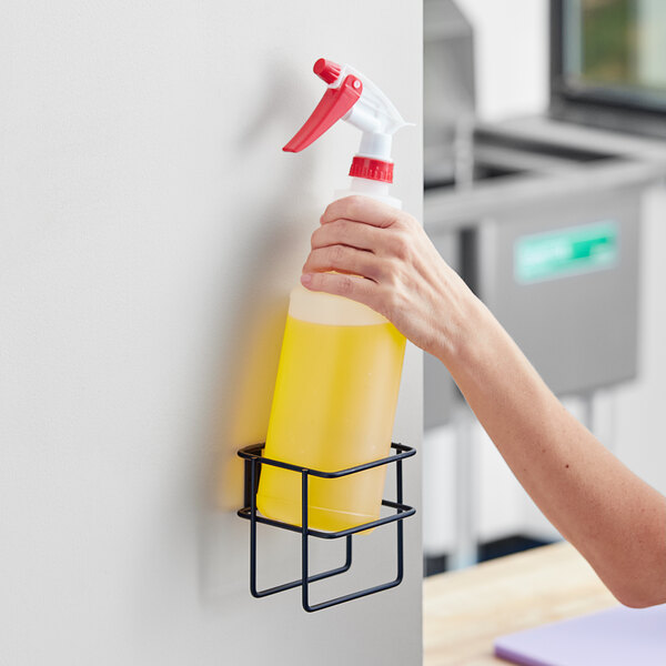 A hand holding a yellow Lavex spray bottle filled with liquid.