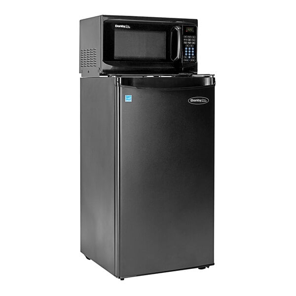 A black Danby refrigerator with a microwave on top.