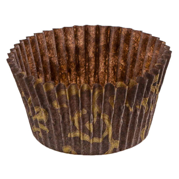A close up of a brown paper Novacart cupcake wrapper with gold designs.