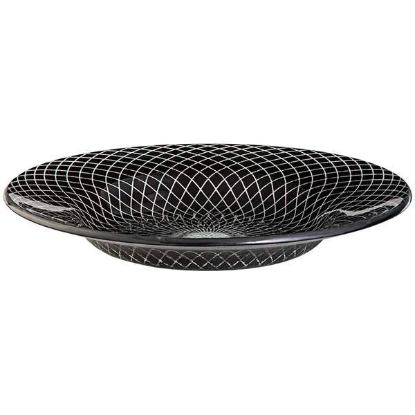 A black glass bowl with a geometric design on the table.