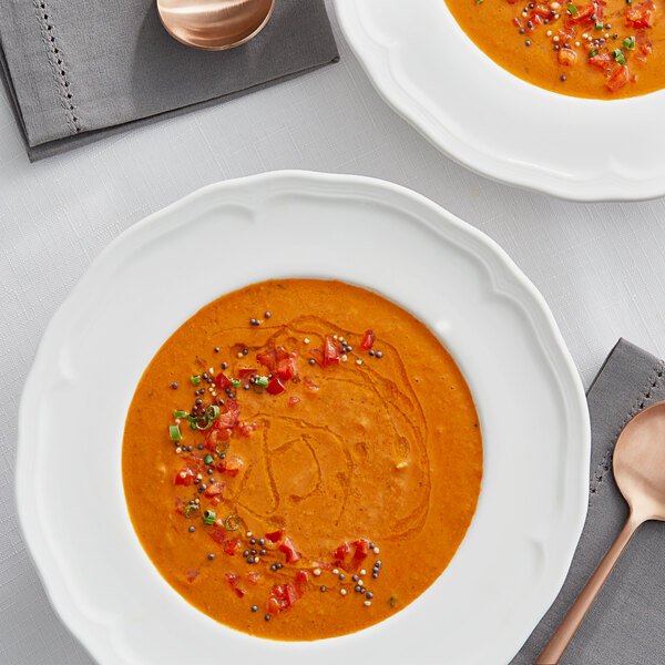 A bowl of Campbell's Roasted Red Pepper and Smoked Gouda Bisque with toppings.