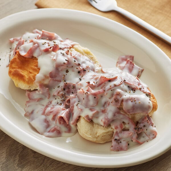 A plate of Stouffer's creamed chipped beef with a biscuit and a fork.