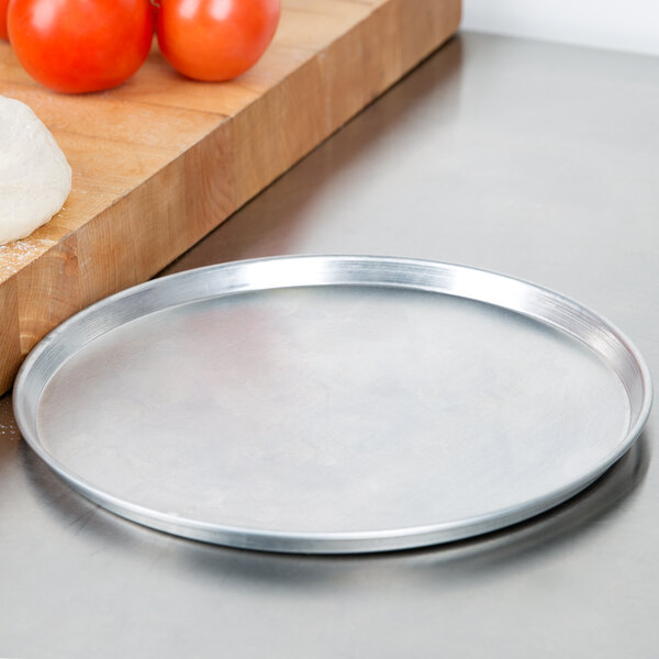 An American Metalcraft aluminum pizza pan on a counter.