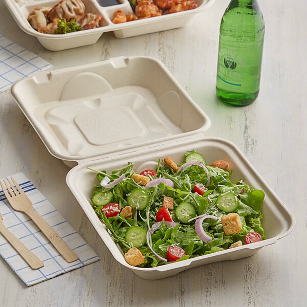 A salad in a World Centric compostable fiber container with a wooden fork.