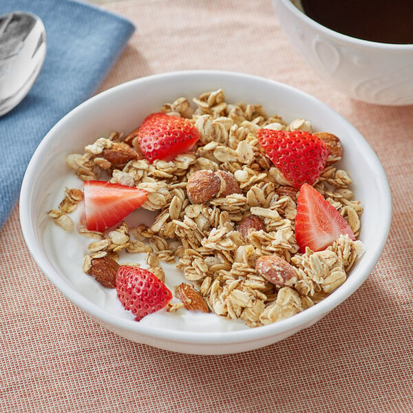 A close up of a bowl of Bear Naked V'nilla Almond Granola with strawberries and nuts.