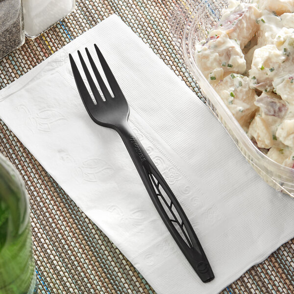 A black Stalk Market heavy weight fork on a napkin next to a bowl of potato salad.