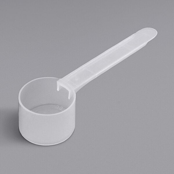 A white plastic measuring spoon with a long handle.