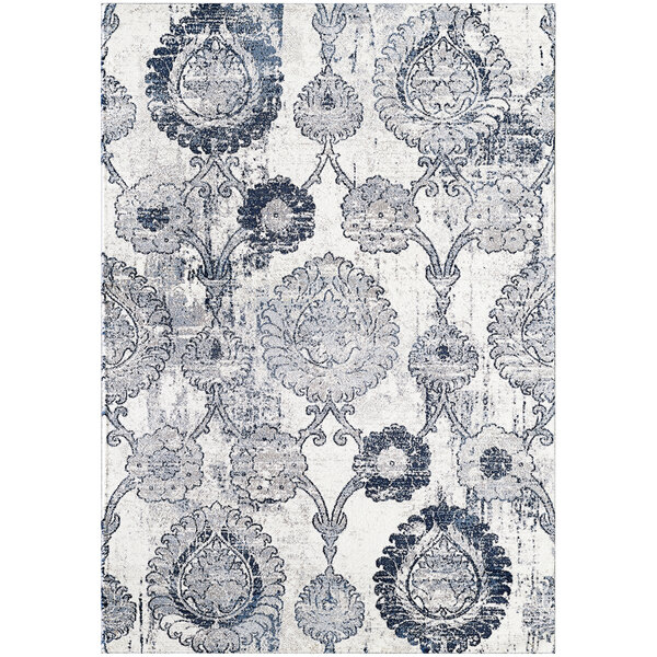 A cream rug with a blue and white distressed medallion pattern.