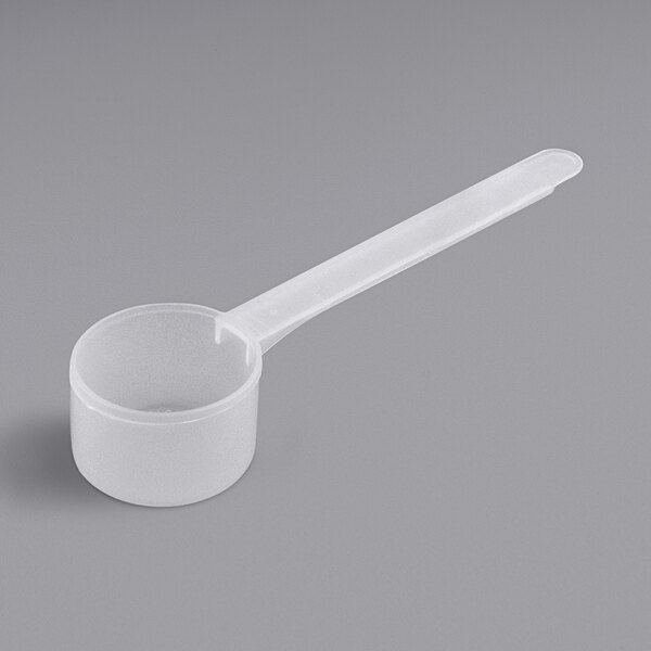 A white plastic measuring spoon with an extra long handle.