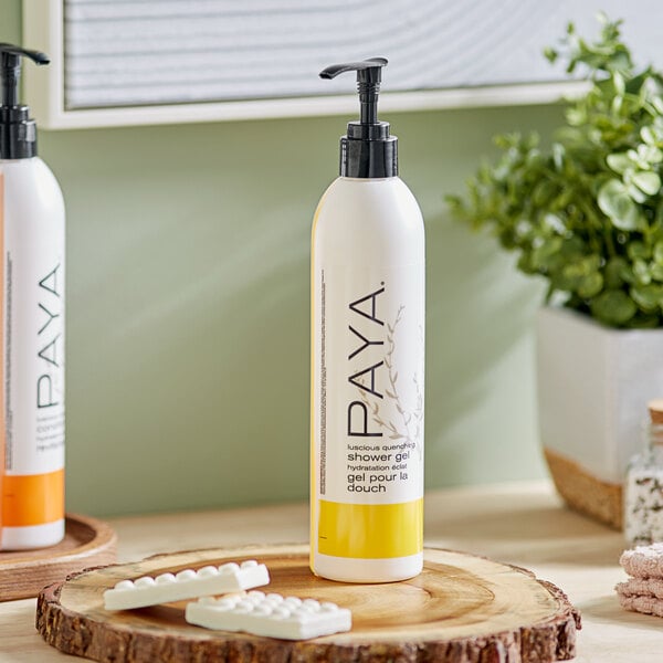 Two bottles of PAYA DoveLok Papaya shower gel on a wooden table.