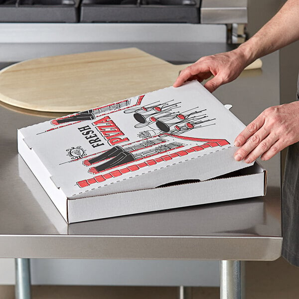 A person holding a Choice white corrugated pizza box on a counter.