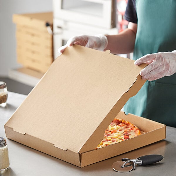 A person in gloves opening a Choice kraft corrugated pizza box.