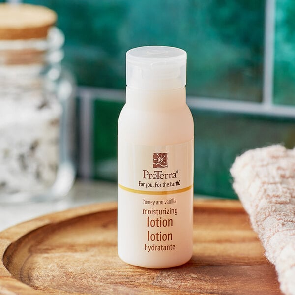 A close-up of a ProTerra Honey and Vanilla lotion bottle on a wooden tray.