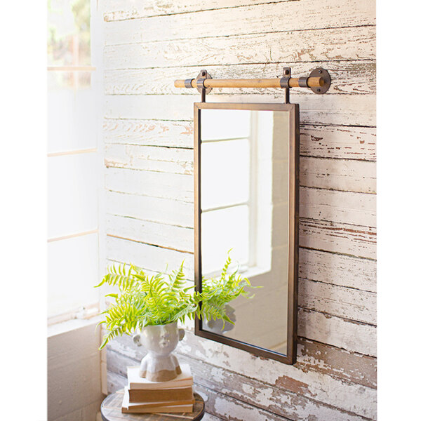 A Kalalou wall mirror with wooden dowel hanger hanging on a wall.