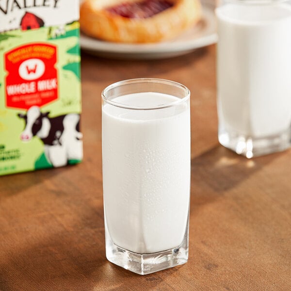 A glass of Organic Valley whole milk on a table.