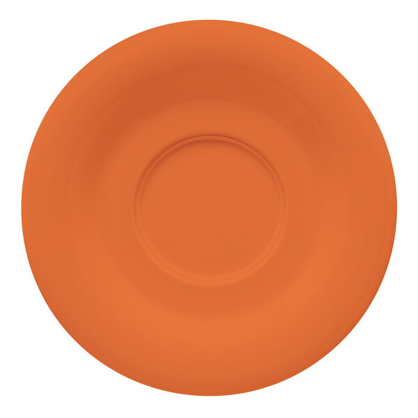A white saucer with a circle in the middle and an orange pumpkin design.